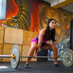 Atleta si prepara al sollevamento pesi, allenamento con Hbs Coaching per la performance sportiva.
